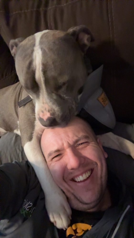 A dog laying across a head on the recliner